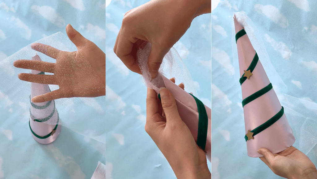 A close-up of hands working with tulle and a decorated pink cone, showcasing a crafting process.